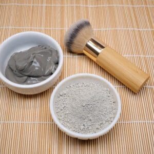 A bowl of clay and a brush on the table