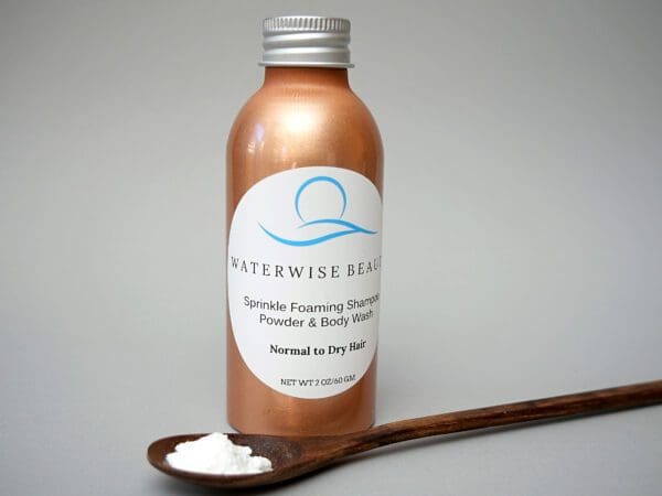 A bottle of lotion next to a wooden spoon.