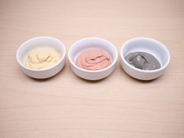 Three bowls of different types of food on a table.