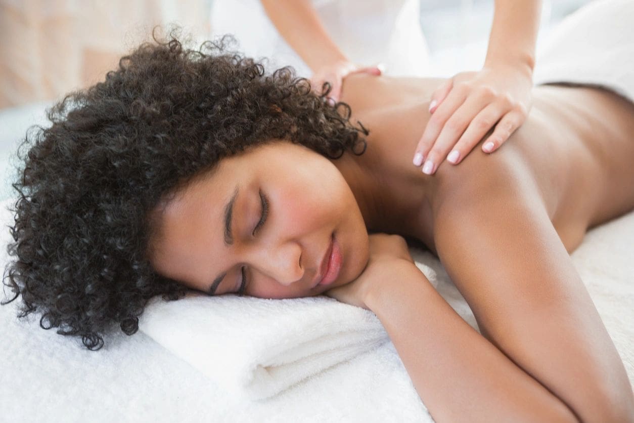 A woman getting a back massage at a spa.