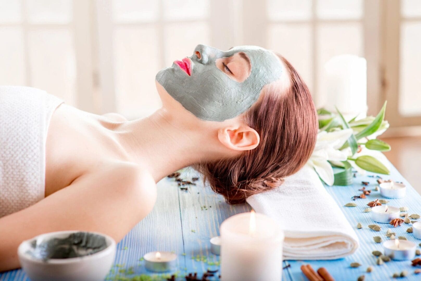 A woman is enjoying an eco-friendly clay mask session at a sustainable spa.
