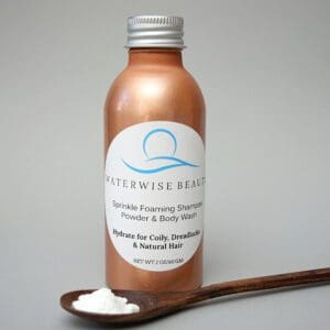 A bottle of lotion next to a wooden spoon.