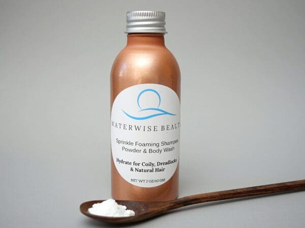 A bottle of lotion next to a wooden spoon.