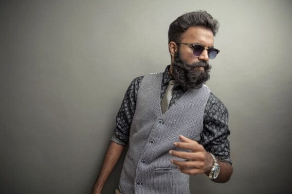 A man with a beard and glasses wearing a vest