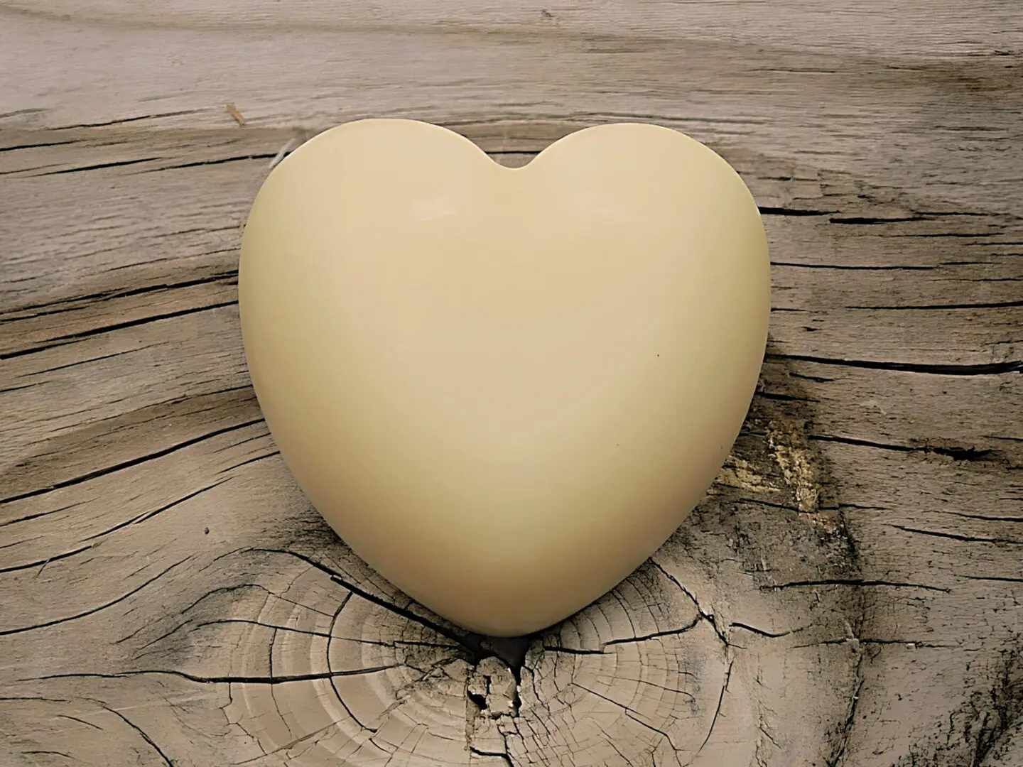 A white heart-shaped Kokum Butter Body Bar resting on a smooth piece of wood.