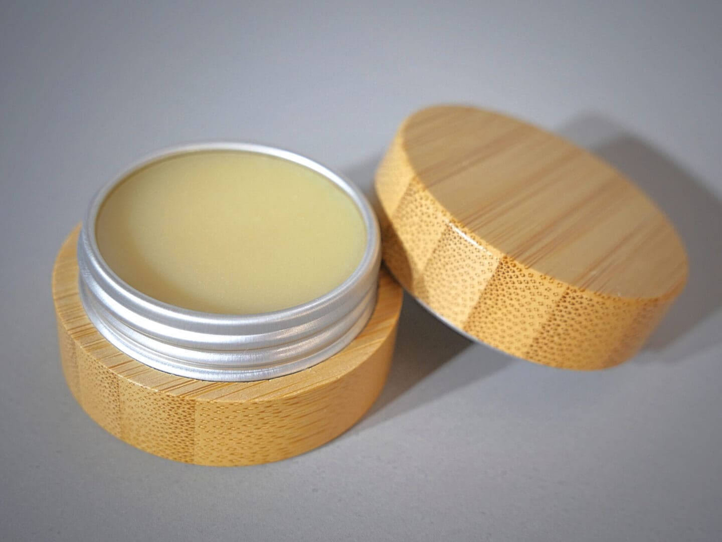 A wooden container with the Hydrate & Restore Lip Balm in it.