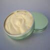 A green tin of cream sits on the table.