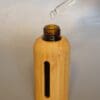 A bamboo bottle with a straw in it.