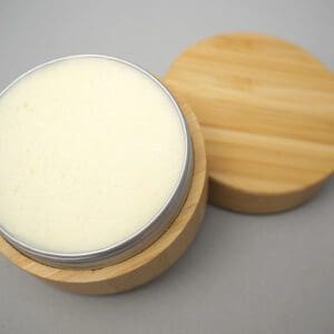 A wooden container with a white lid next to another container.