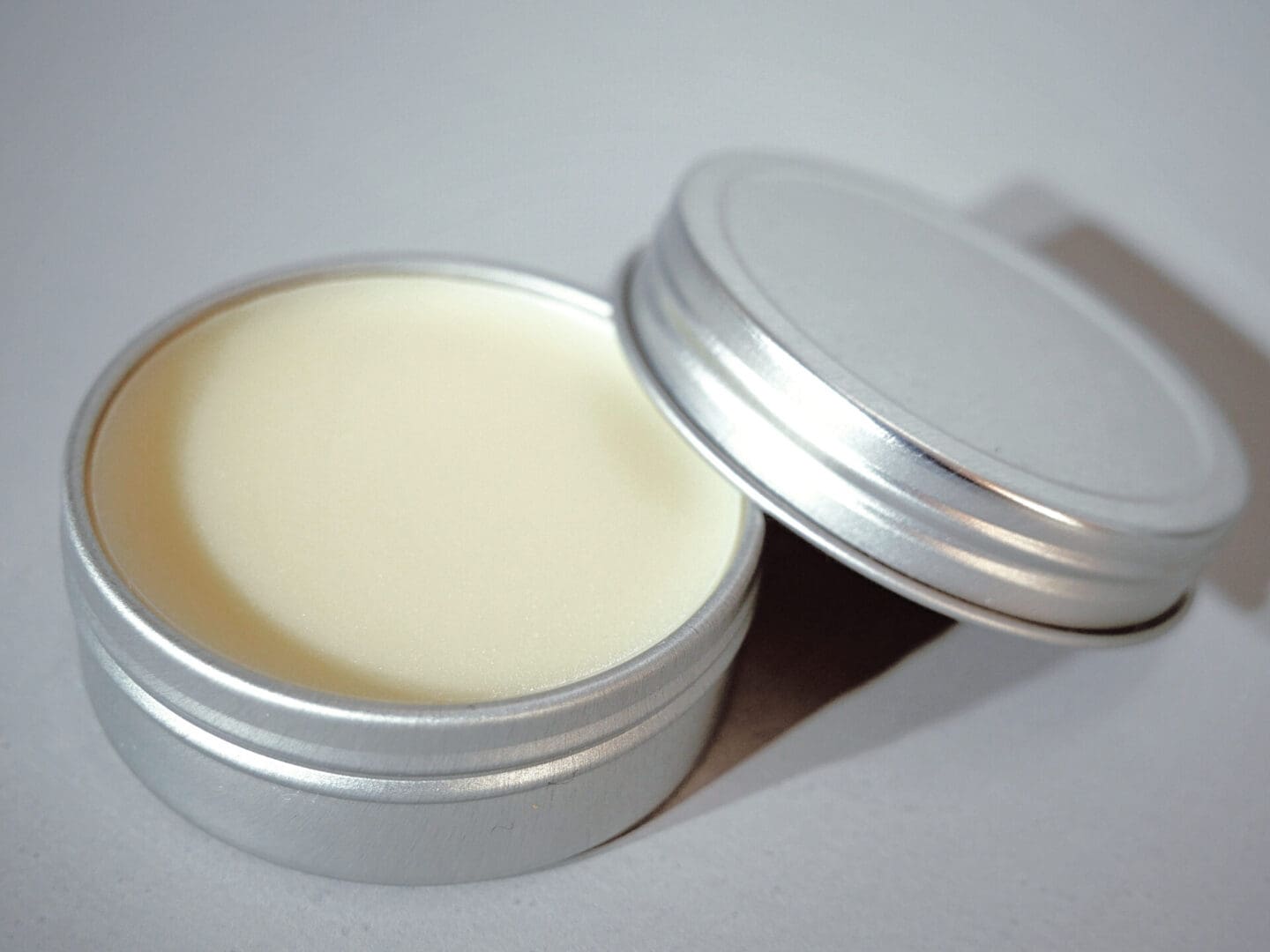 A small tin of lip balm with a lid.