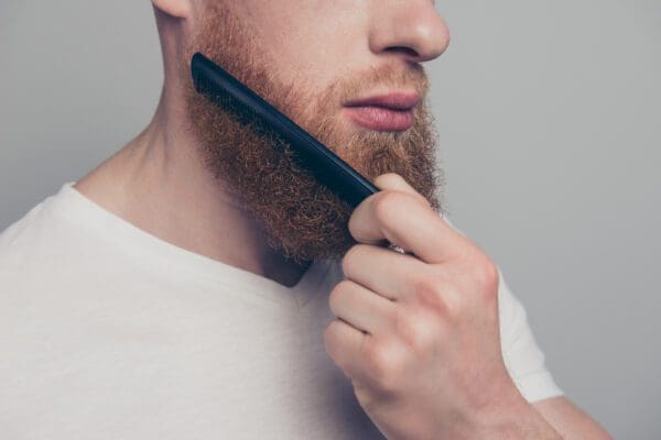 A man with a beard is holding a comb