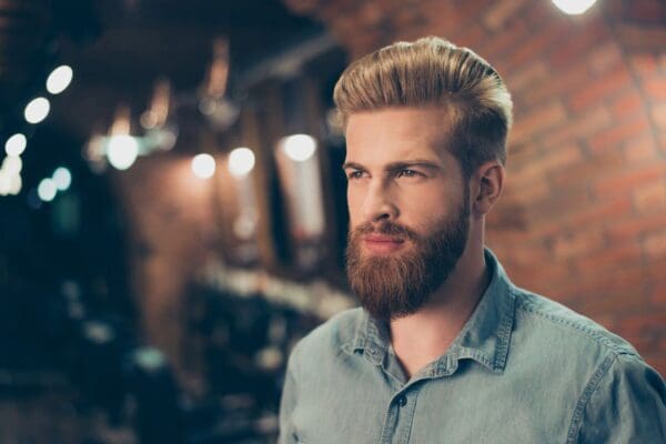 A man with a beard and mustache is looking at the camera.